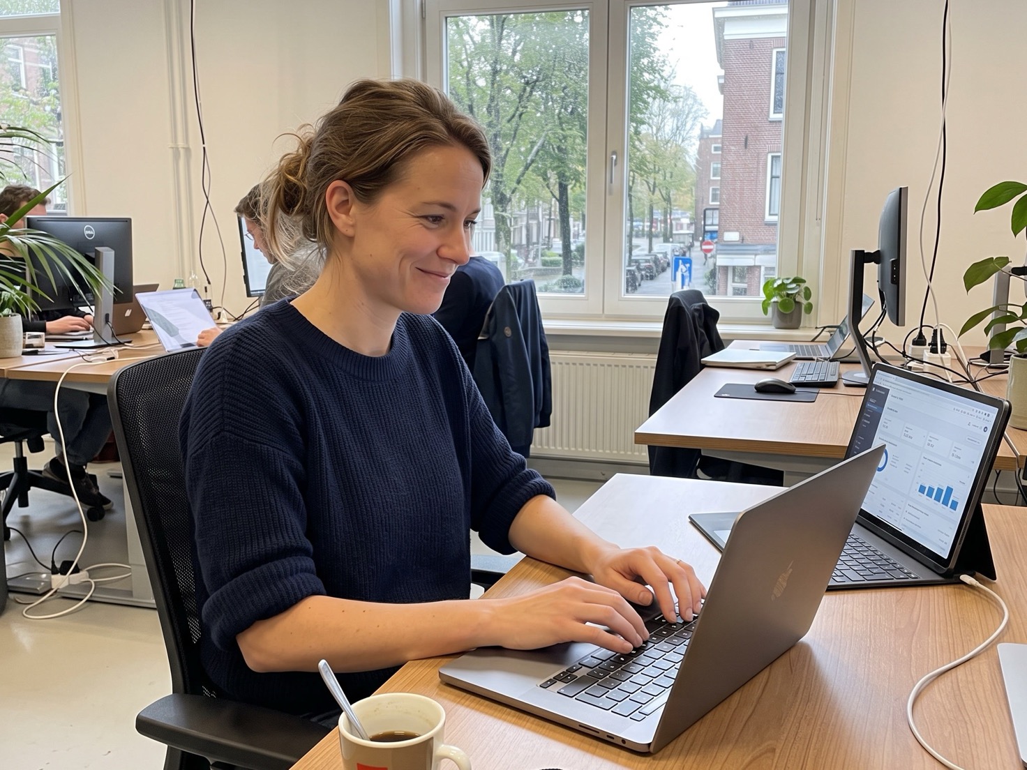 Vrouw werkt geconcentreerd achter haar laptop in een rustig thuiskantoor