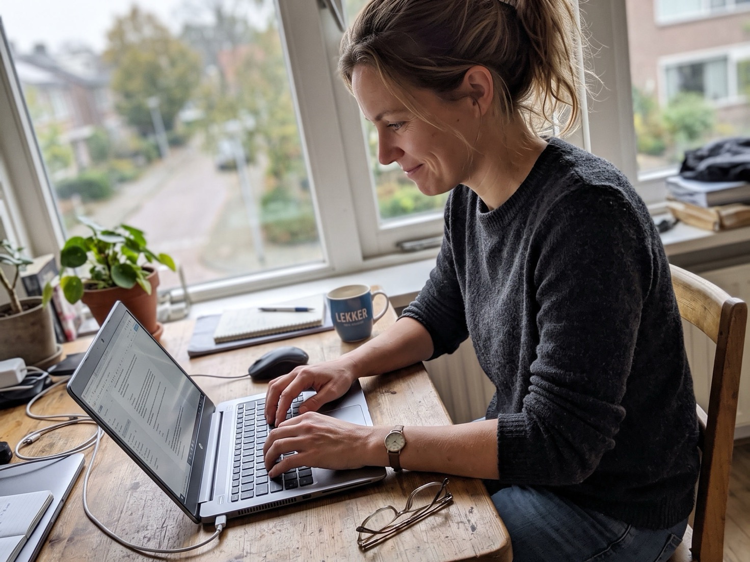 Vrouw werkt geconcentreerd achter haar laptop aan de werktafel
