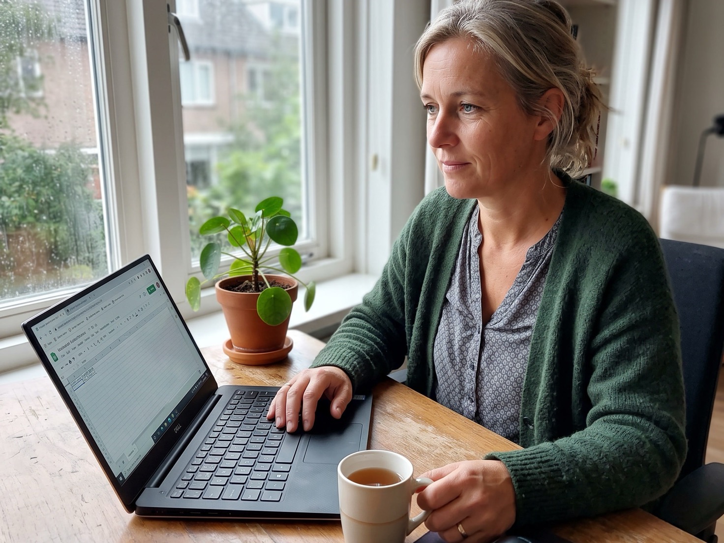 Vrouw werkt geconcentreerd achter haar laptop aan haar bureau thuis
