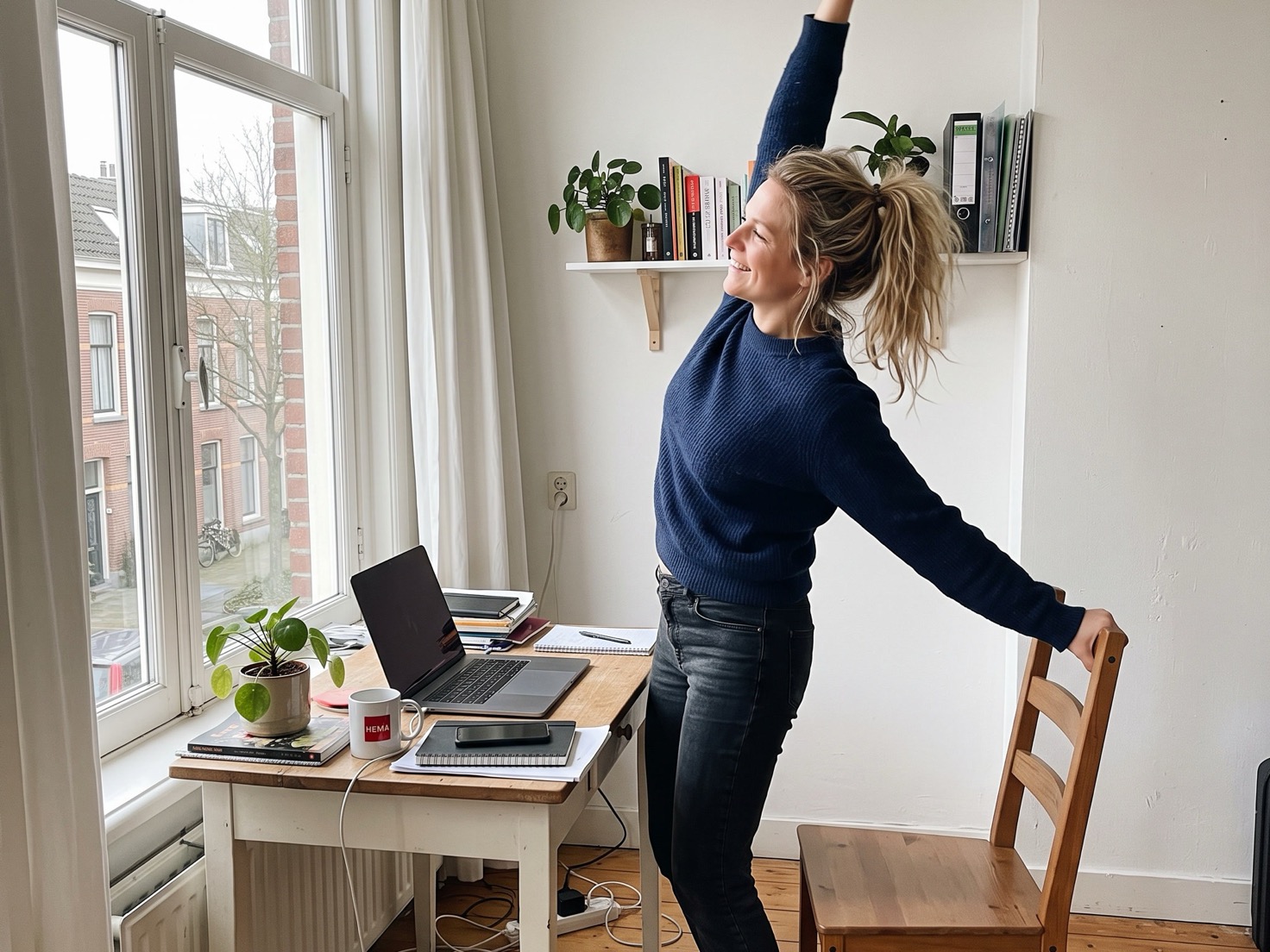 Vrouw van rond de 45 staat op van haar bureau in haar thuiskantoor na het dichtklappen van haar laptop