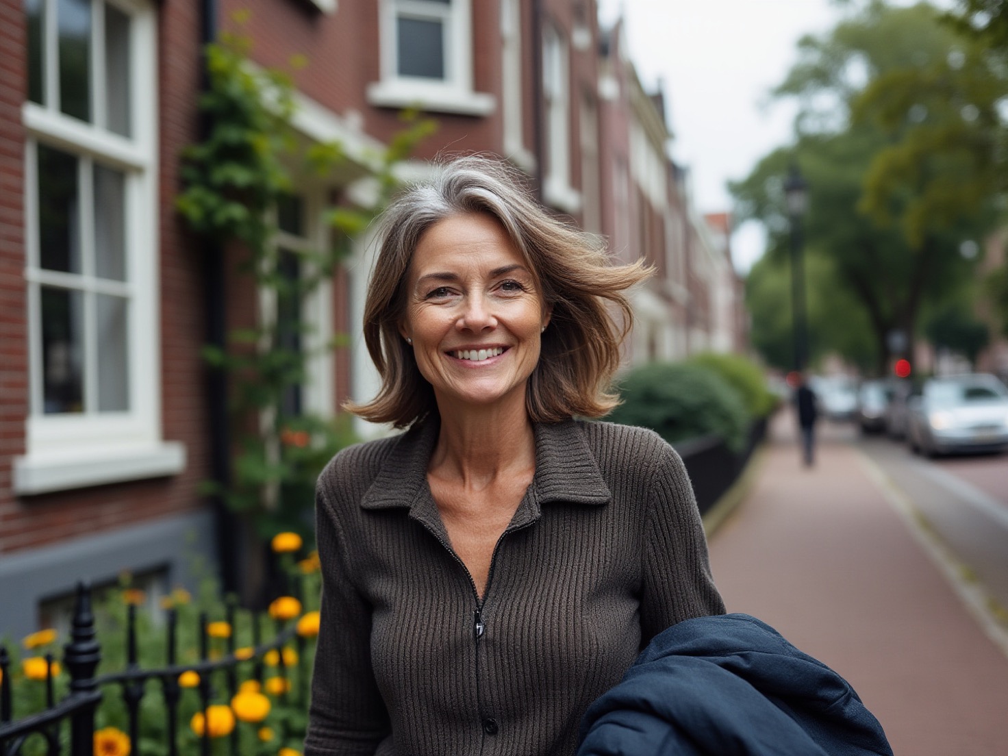 Vrouw van rond de 49 loopt rustig door een Nederlandse straat met rijtjeshuizen