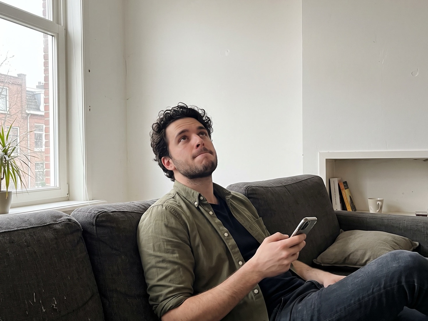 Solo-ondernemer checkt op de bank op zijn telefoon of zijn blog al gevonden is door Google