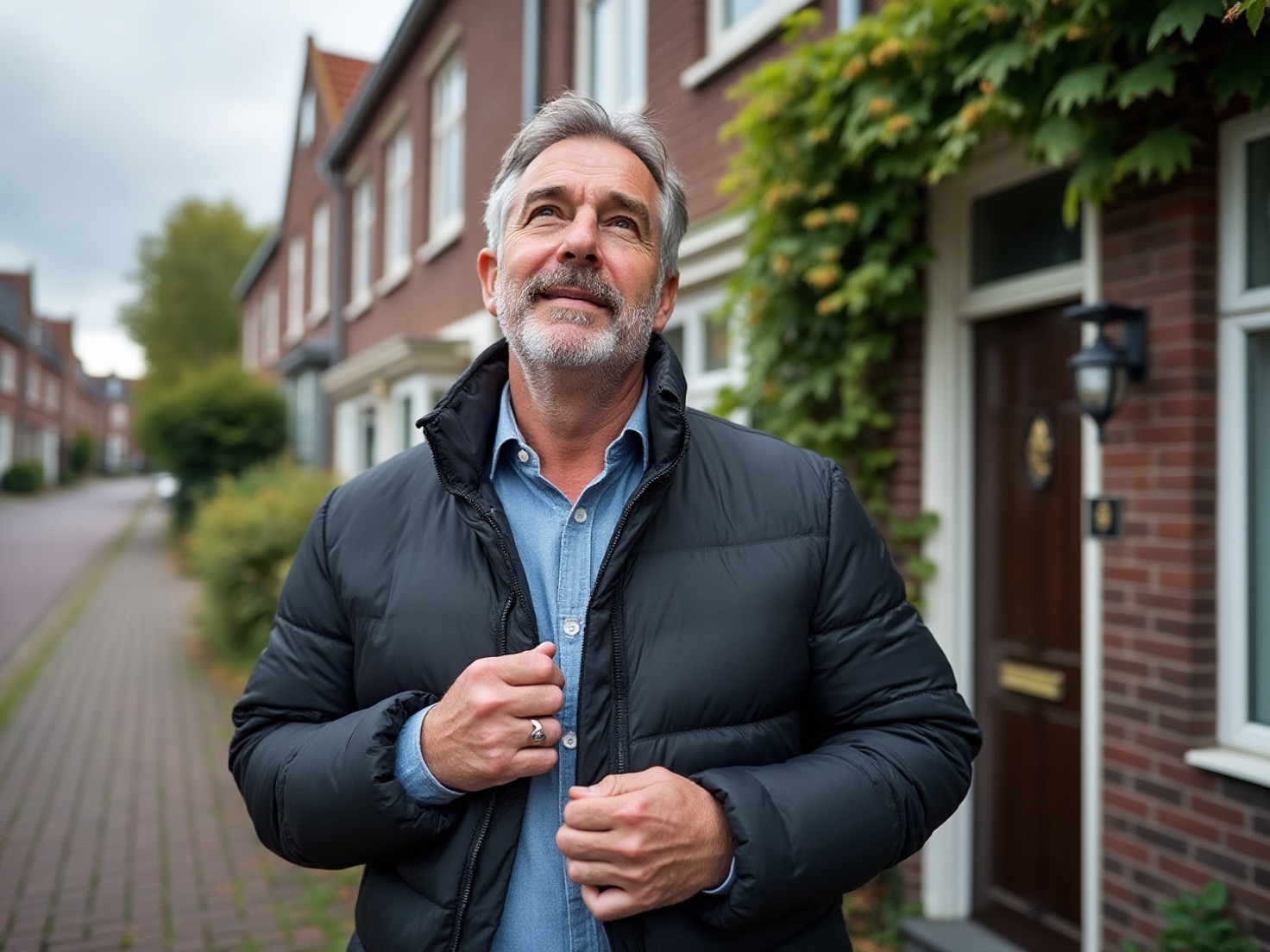 Solo-ondernemer staat rustig nadenkend voor zijn huis op een Nederlandse straat