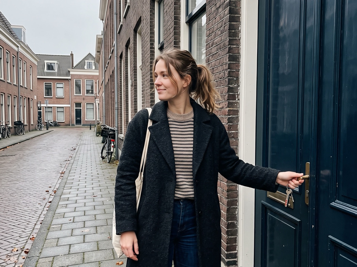 Vrouw stapt met haar sleutels in haar hand naar buiten voor haar pand
