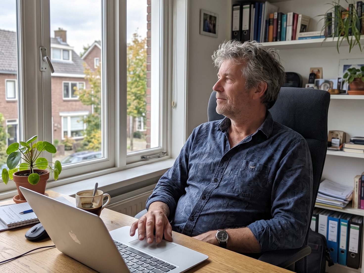 Solo-ondernemer leunt tevreden achterover achter zijn laptop na afloop van een klantgesprek