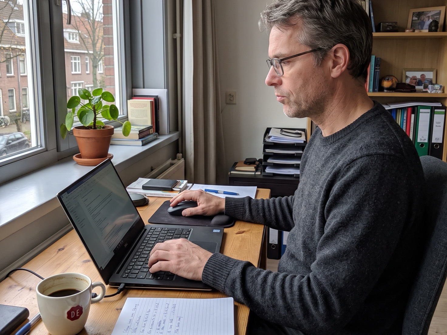 Zzp'er werkt aan een nieuwsbrief achter een laptop in een thuiskantoor