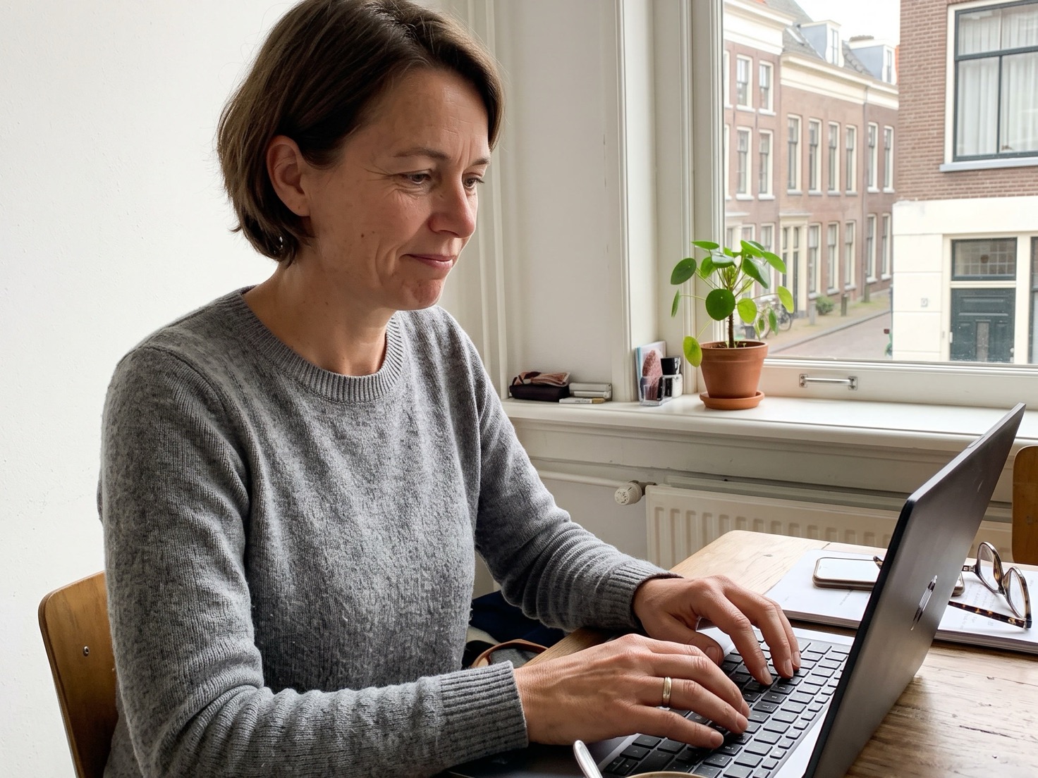 Zelfstandig ondernemer twijfelt achter haar laptop over een opvolgmail