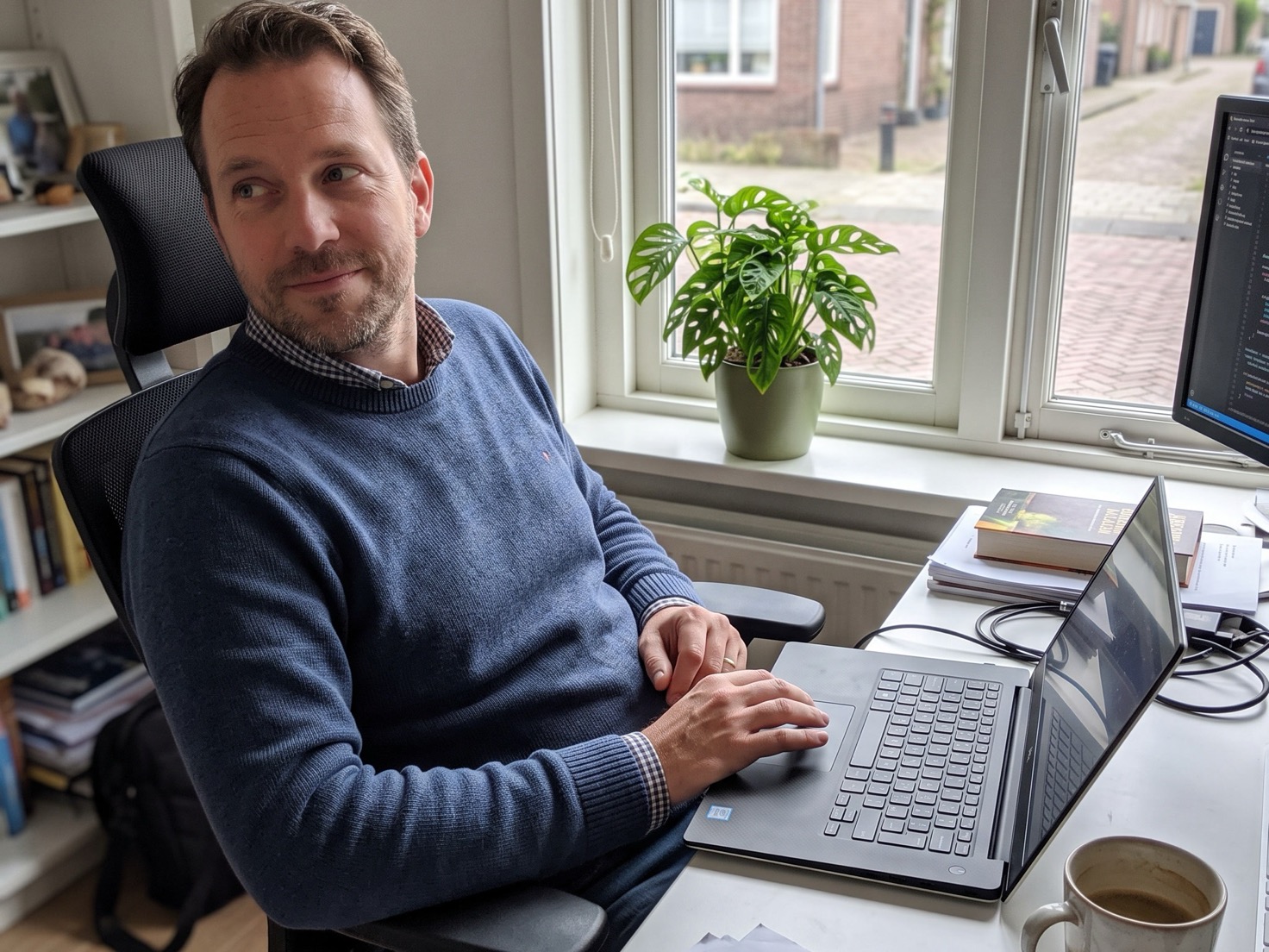 Ondernemer denkt na achter zijn laptop over een samenwerkingsverzoek van een merk